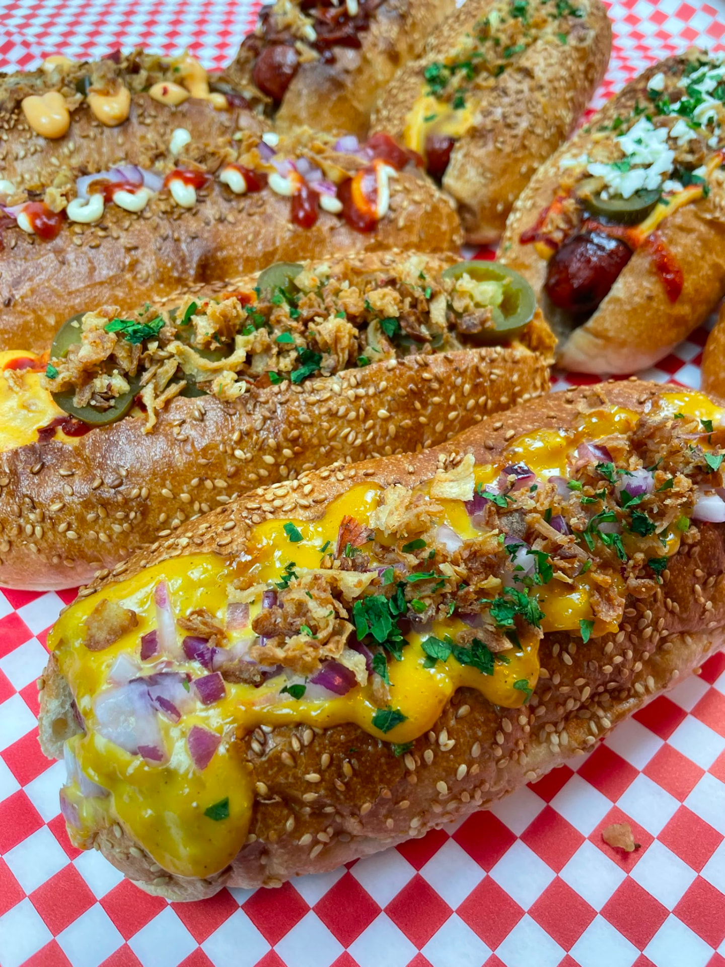 Frisch belegte Hotdogs mit Cheese Sauce, Röstzwiebeln und Jalapeños